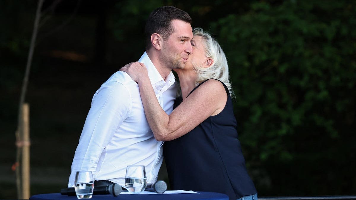 French right-wing party National Rallly (RN) president Jordan Bardella (L) and President of National Rally parliamentary group Marine Le Pen hug as they attend a RN party event "La fete champetre" in Lievin, northern France on July 4, 2026.