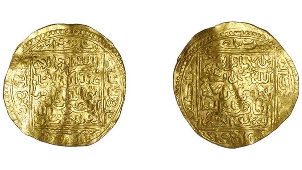 Moroccan gold coins on display with Arabic writing