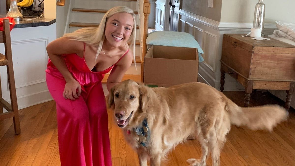 Eva Benefield smiling and leaning next to her dog.