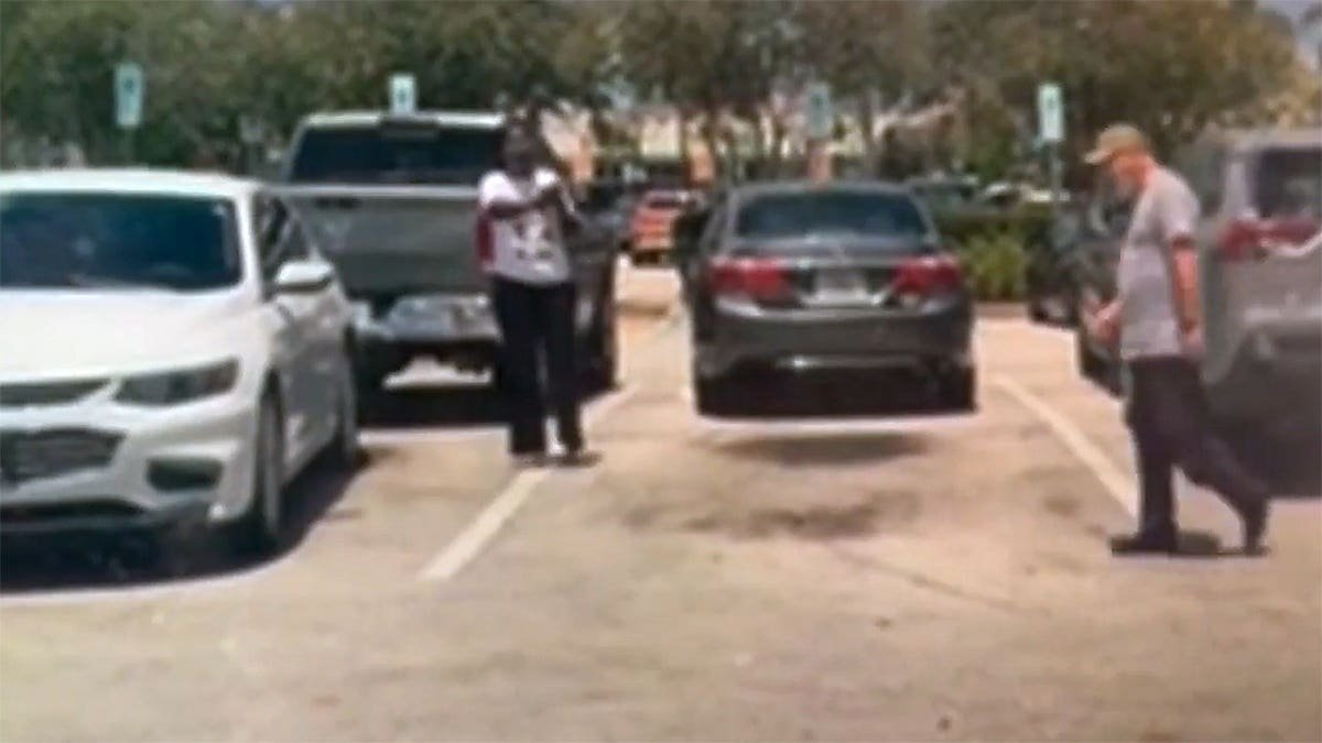 A woman raises her arm toward Bart Diguglielmo during a confrontation in a Walmart parking lot moments before the fatal shooting.