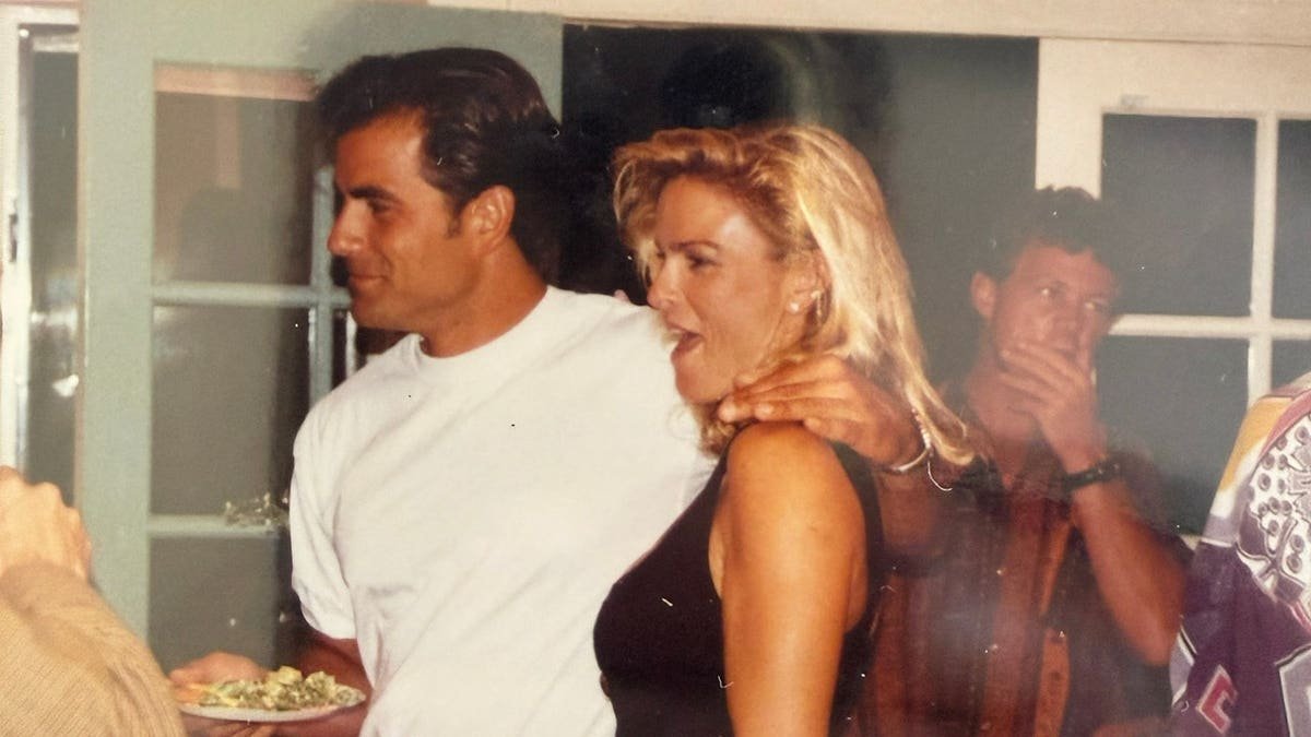 Joseph Perrulli in a white shirt embracing Nicole Brown Simpson in conversation.