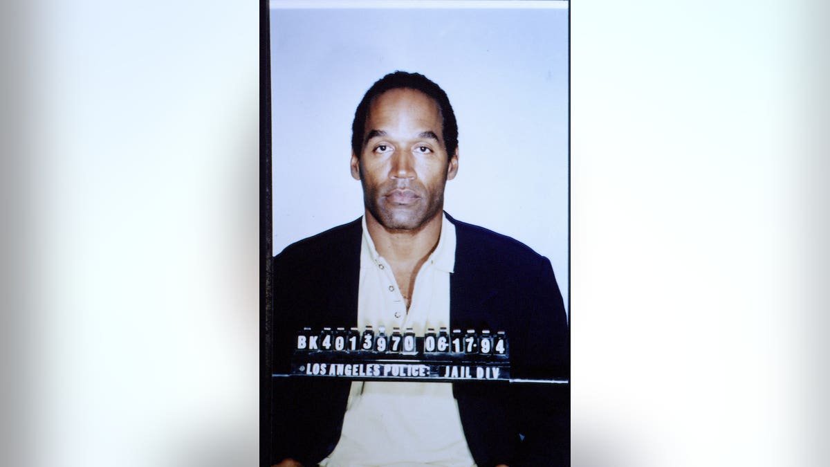 O.J. Simpson stands during his trial in a courtroom.