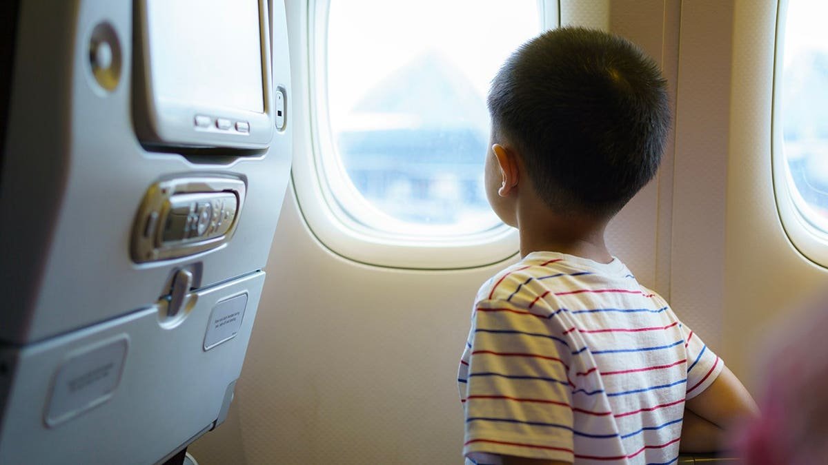 Child looking out of plane window