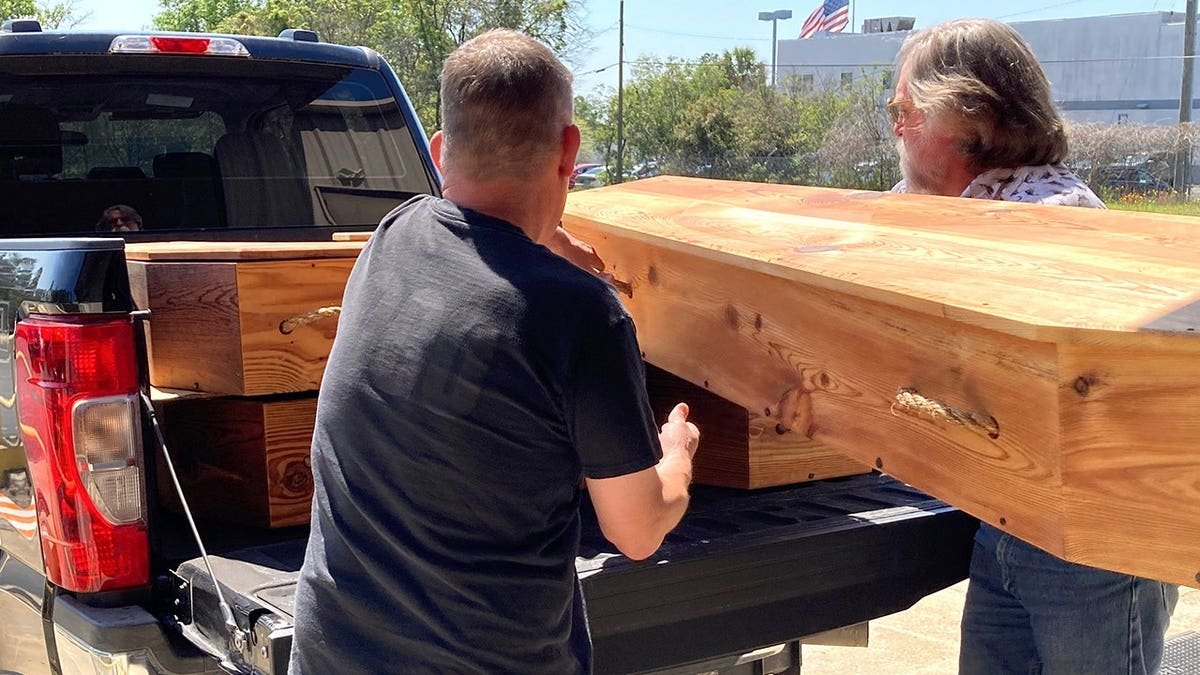 View of researchers carrying Pumphrey's coffin