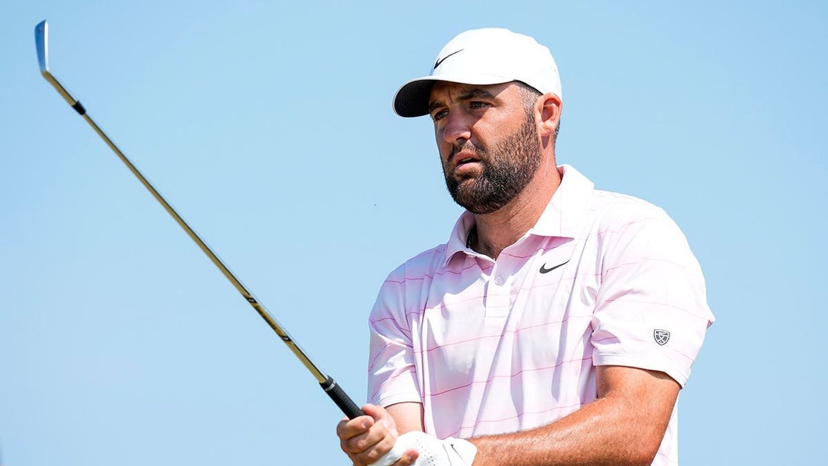 Scottie Scheffler stands on the fifth tee at a golf course.