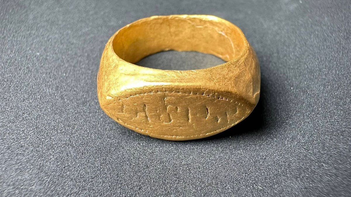 Close-up of gold ring with inscription