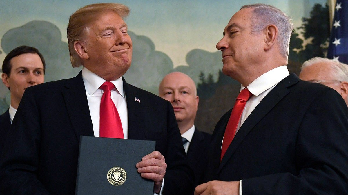 Donald Trump smiles at Israeli Prime Minister Benjamin Netanyahu, right, after signing a proclamation at the White House in Washington.