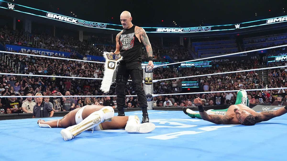 Baron Corbin looks down at Trick Williams in the ring.