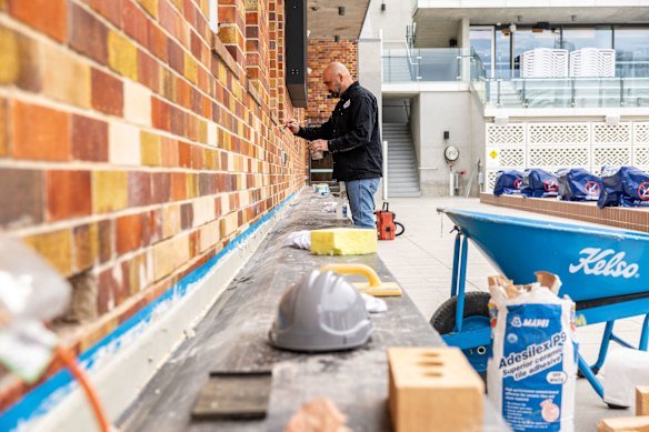 Conservator Pawel Ptaszek adds the finishing touches to a brick wall at the state heritage-listed pool complex.