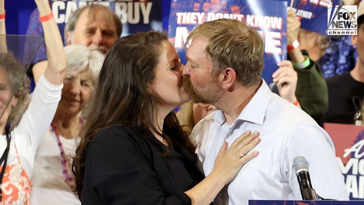 Graham Platner and his wife, Amy Gertner kiss at his watch party