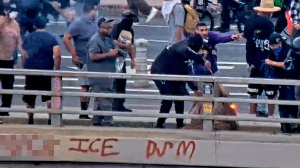 People on the Main Street overpass in Los Angeles appear to ignite debris during anti-ICE riots on June 8, 2025