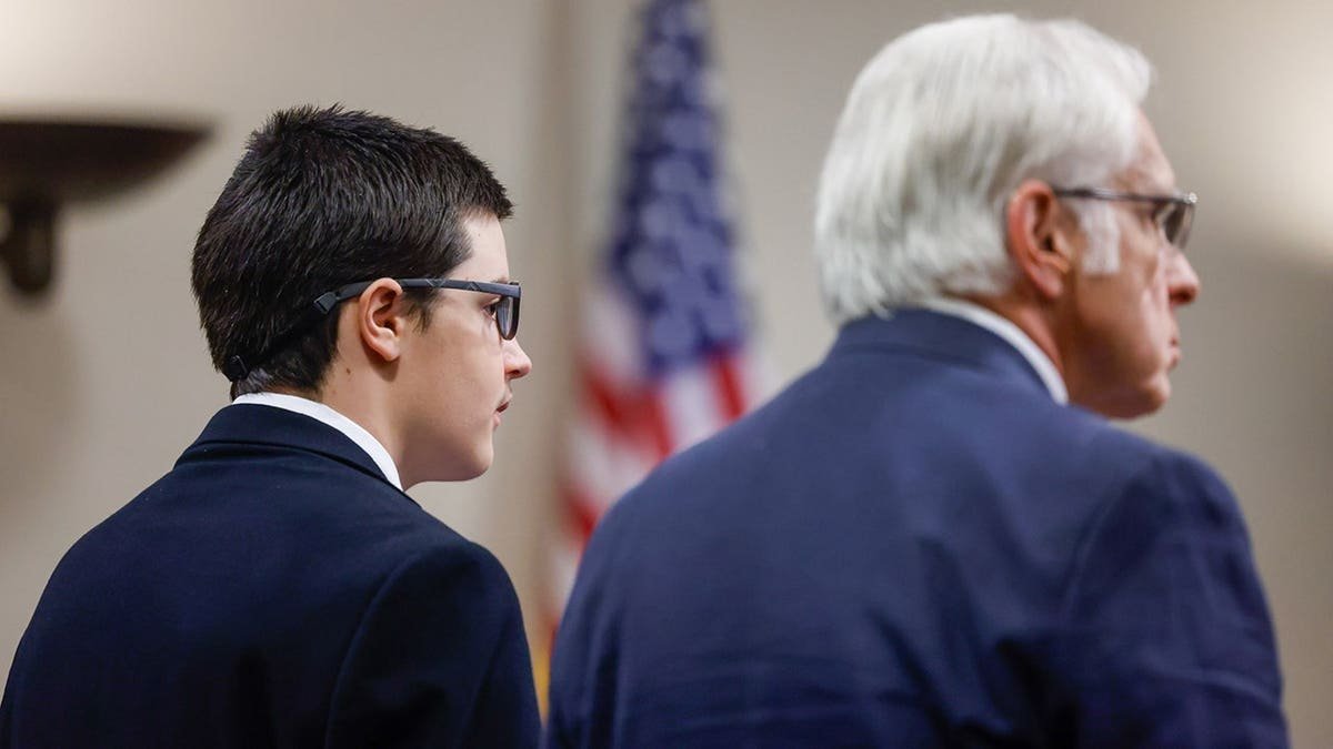 Colt Gray stands beside his attorney Charlton Allen in a courtroom.