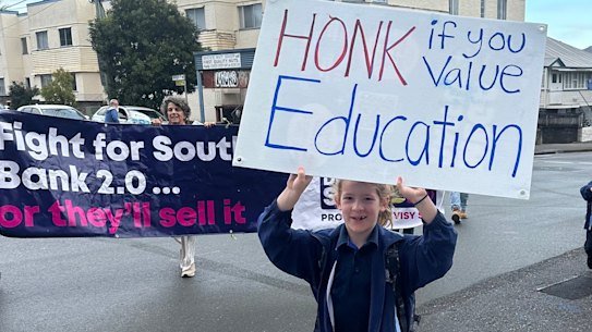 Students and parents held placards and banners in front of West End State School on Monday.