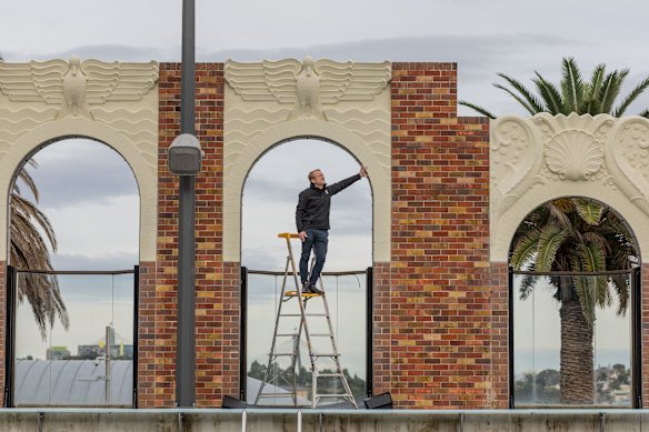 Traditional Restoration Company managing director James Ginter inspects the restored art deco wall at the pool.