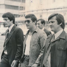 Mark “Chopper” Read (centre) heading to court after pointing a shotgun at a judge.