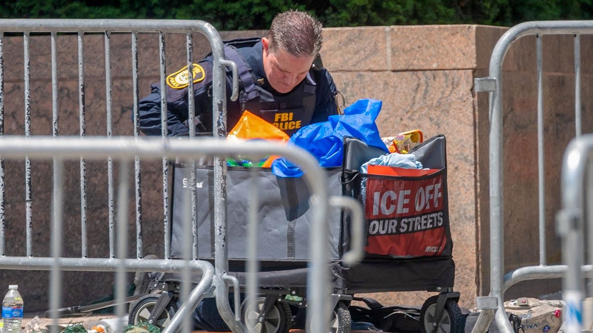 A federal officer investigates the scene after an incendiary device went off outside 26 Federal Plaza in Lower Manhattan early on Monday in New York City.