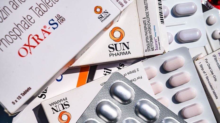 Boxes of generic prescription medications and blister packs of tablets are displayed together