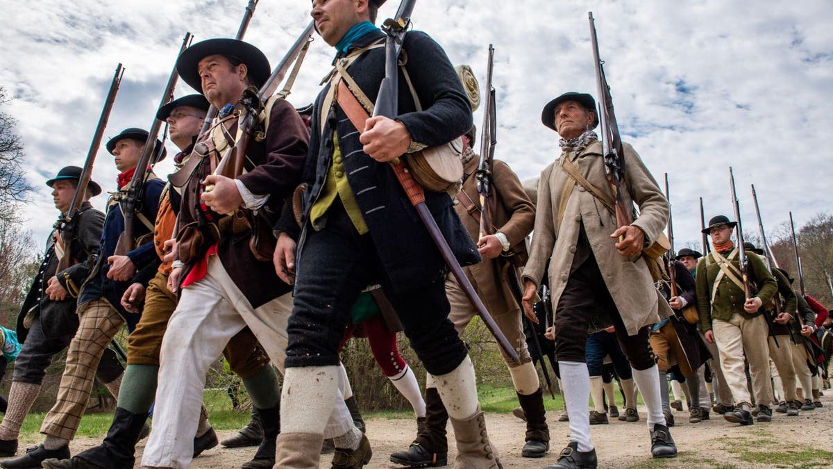 Joseph Prezioso leading colonial militia reenactors marching in formation at Minute Man National Historical Park