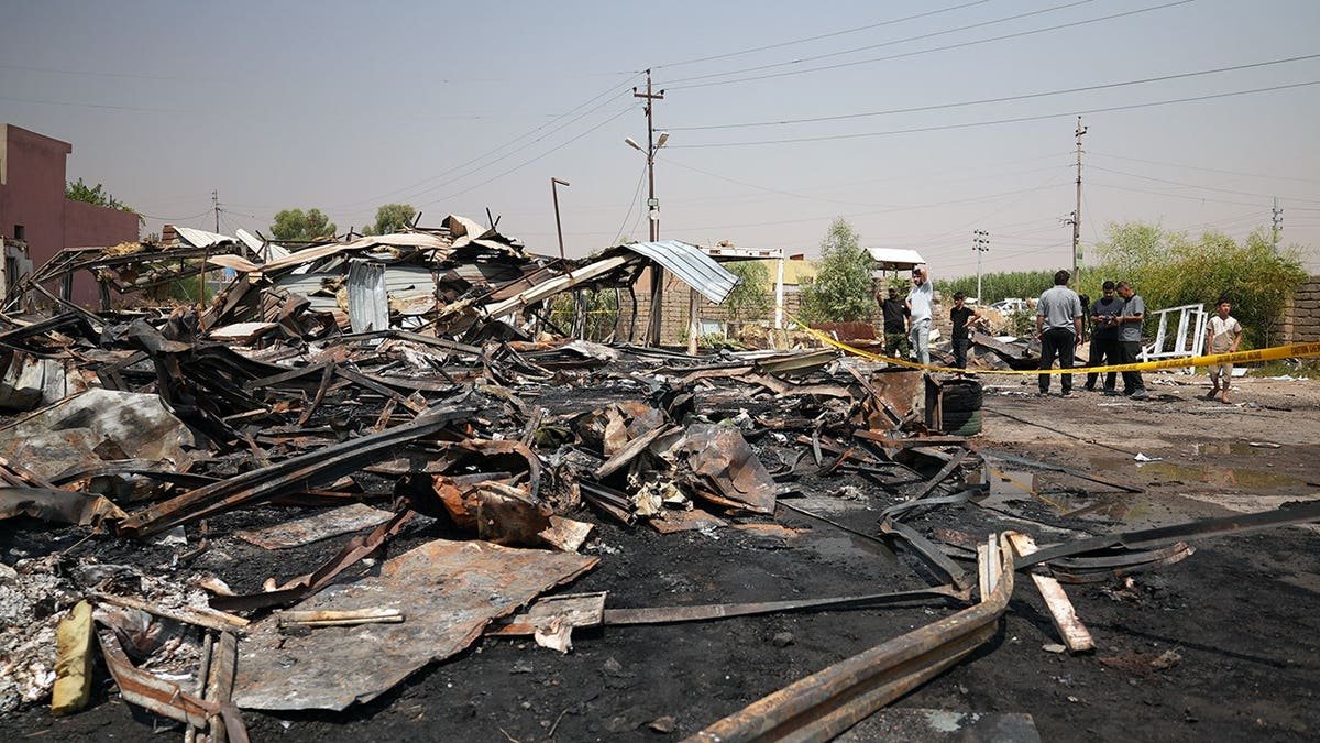 Iraqis inspect damaged structures at an airstrike site in Mosul, Iraq.