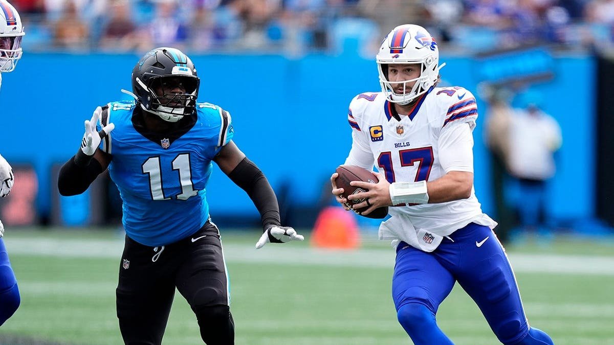 Josh Allen scrambles as Nic Scourton pursues during an NFL game.