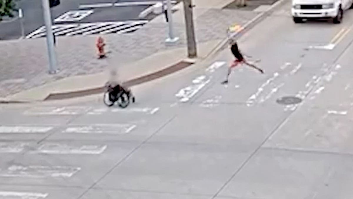 A suspect seen about to throw a Molotov cocktail at another man in a wheelchair