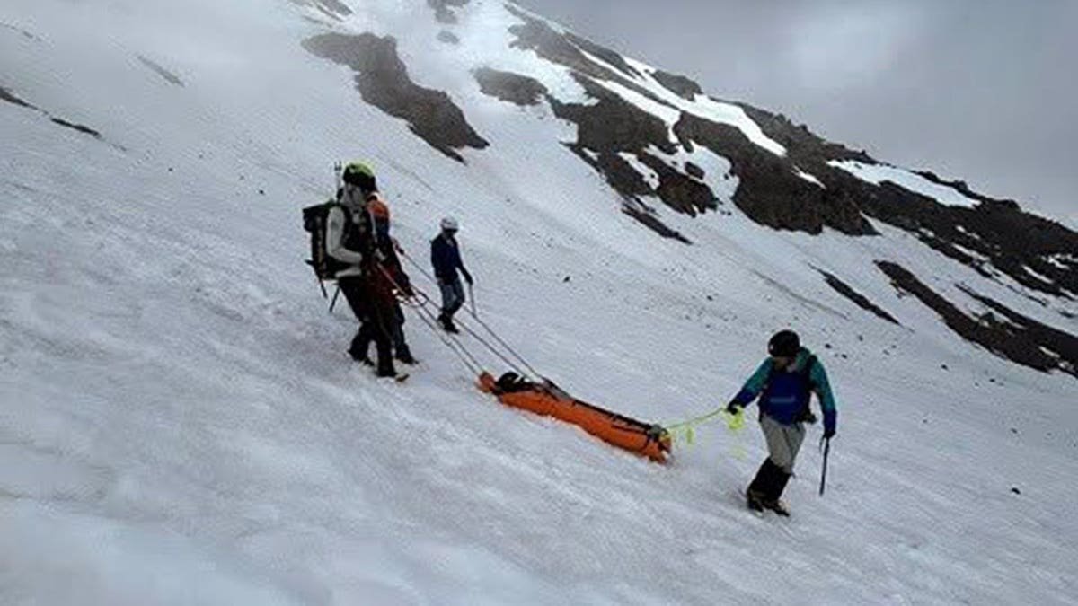Climbing rangers lower injured Mount Shasta climber on rescue litter
