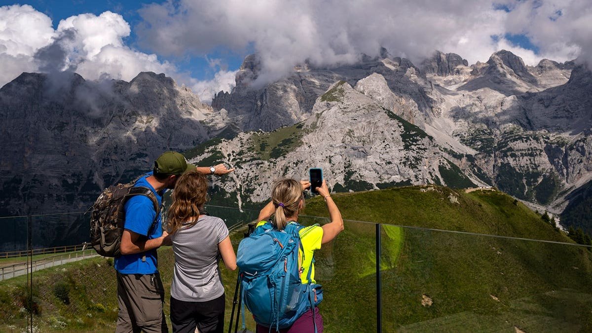 People take photographs at the Brenta Dolomites in Pinzolo, Italy.