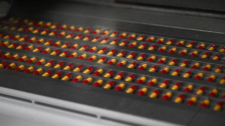 Capsules move along a pharmaceutical manufacturing production line