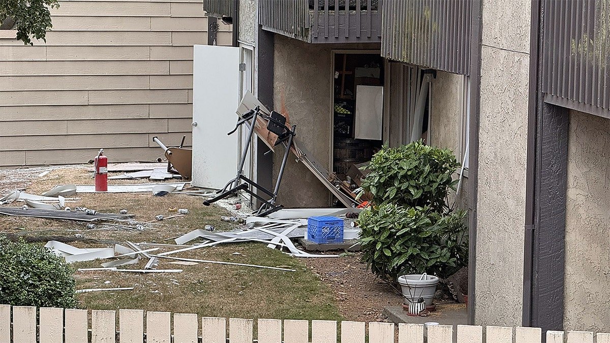 Firefighters and a police officer stand outside a Tacoma apartment complex after an explosion prompted evacuations.