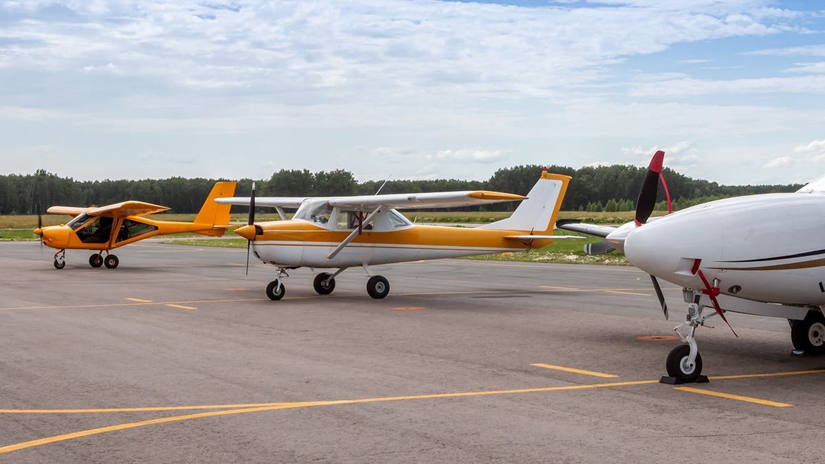 Private airplanes parked at an airfield.
