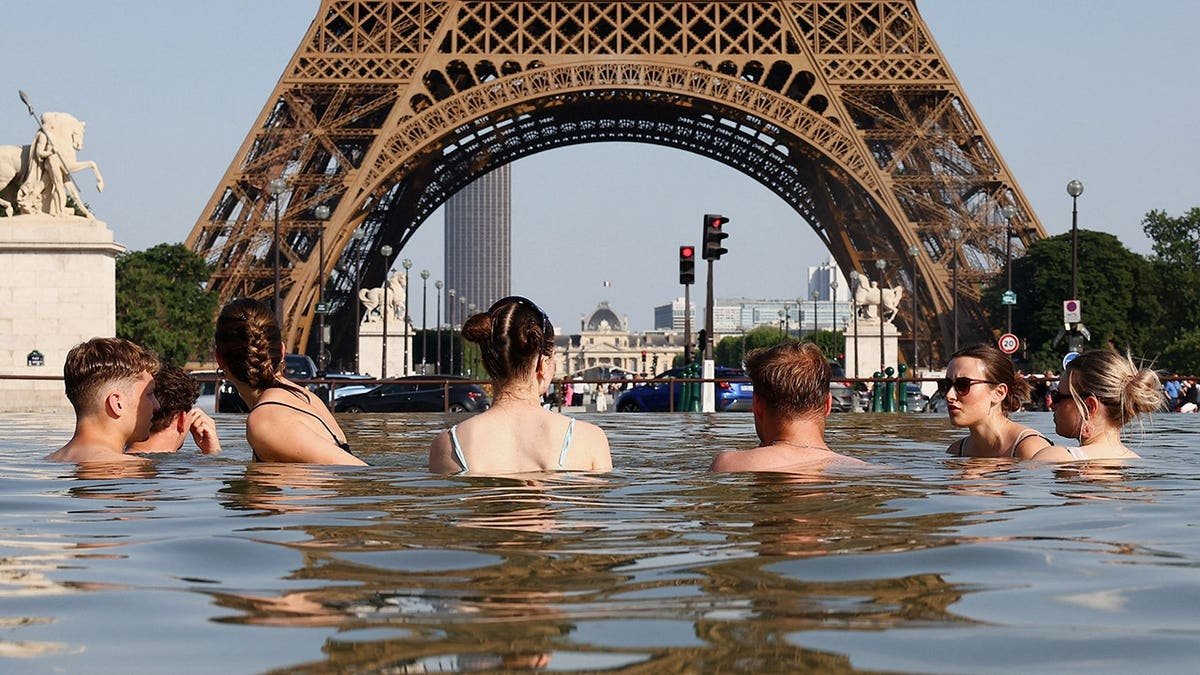 People cooling off in the Trocadero Fountain near the Eiffel Tower in Paris