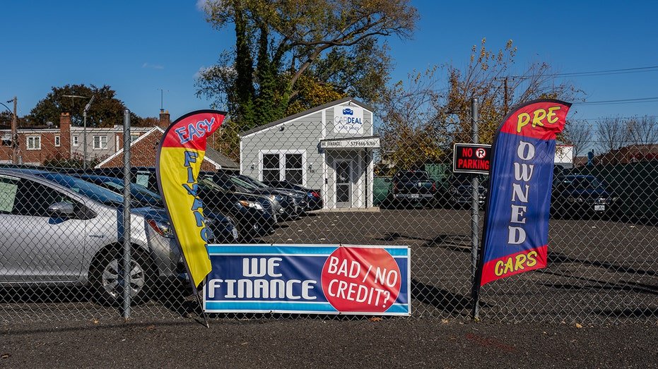 Signage advertising used cars and financing at a used car dealership.