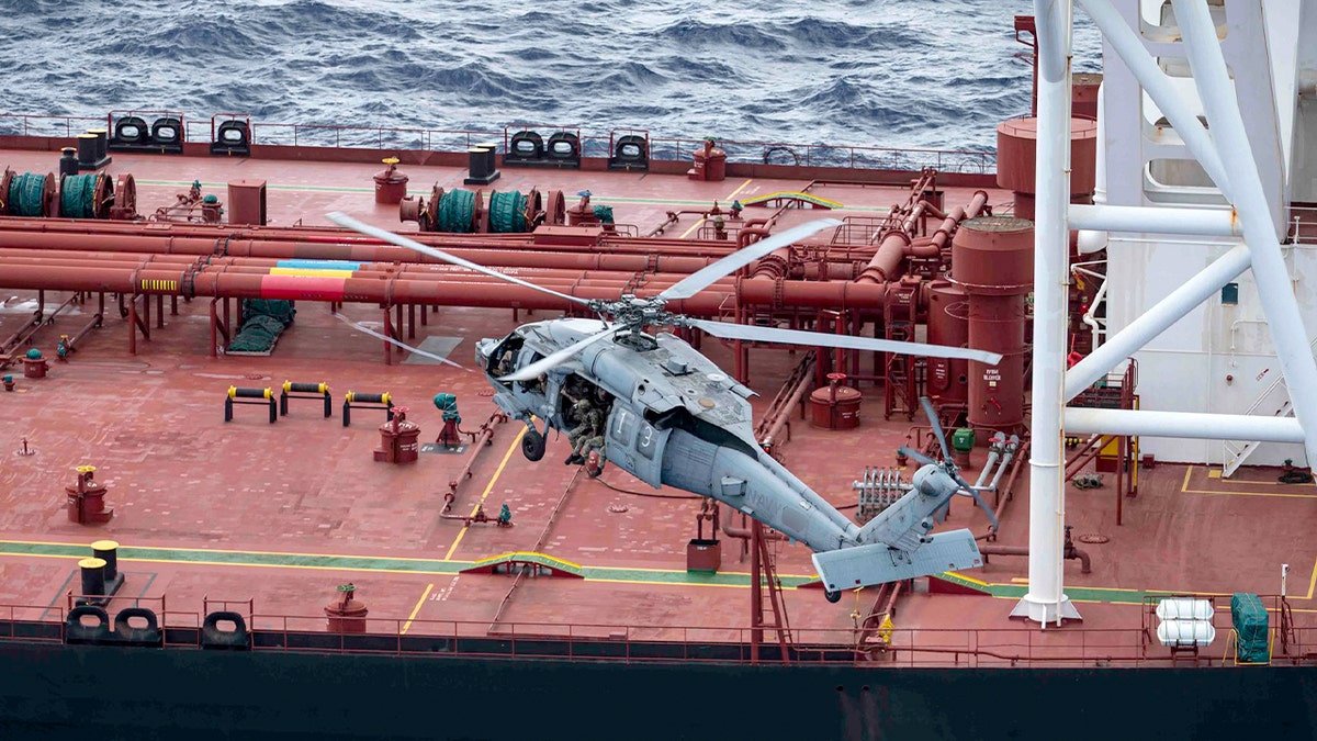 A helicopter lands on the Veronica III vessel at sea.