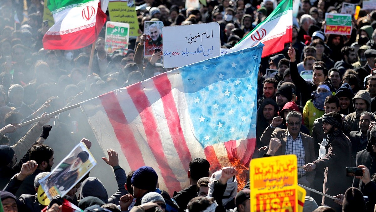 Iranians burn a U.S. flag during a rally at Azadi (Freedom) Square celebrating the 41st anniversary of the Islamic Revolution, in Tehran, Iran, Tuesday, Feb. 11, 2020. (AP Photo/Ebrahim Noroozi)