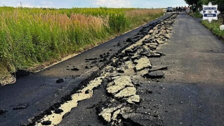 Man in Poland drives tractor onto fresh asphalt, churning up road Man in Poland drives tractor onto fresh asphalt, churning up road