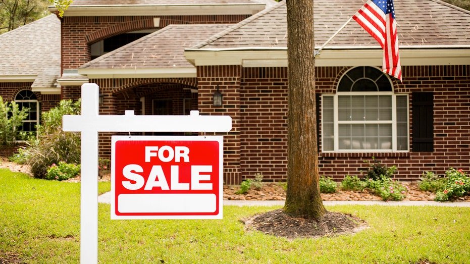 Home with a "for sale" sign.