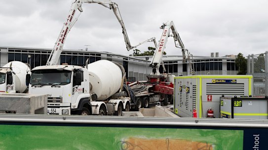 Workers fill in a huge sinkhole with cement in March 2024 to stabilise a two-storey building that had teetered on the edge.