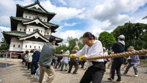 Hundreds of volunteers pull 360-tonne historic Japanese castle back into place by hand
