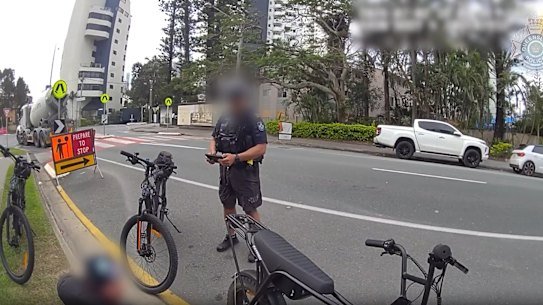 Queensland Police intercepting e-motorbike riders as part of its e-mobility crackdown targeting e-bikes and e-scooters, called Operation Surety. Video of Operation Surety, Gold Coast from a QPS email dated July 6, 2026. A bike was seized and a 27-year-old man was issued with an infringement notice for riding at speed without pedalling on a non-compliant bike.