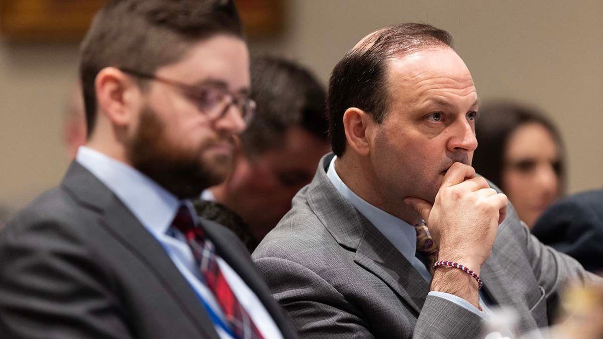 A man looks on while inside a courtroom.