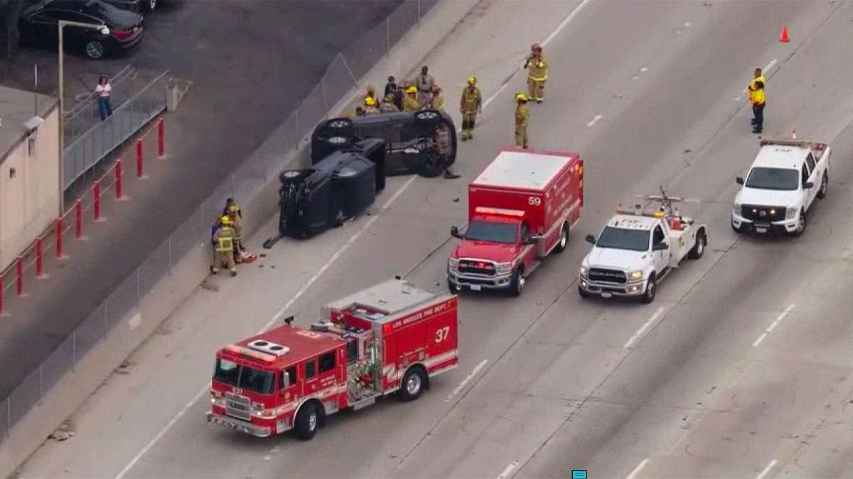 Emergency crews surround two overturned cars following a crash on the 405 Freeway in Los Angeles
