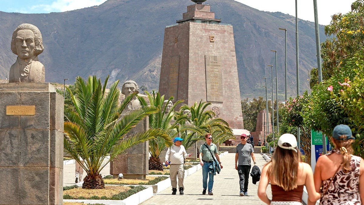 View of tourists walking through Ecuador with mountains in background