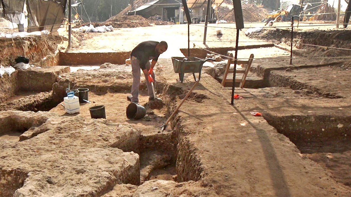 Archaeologist digging at excavation site
