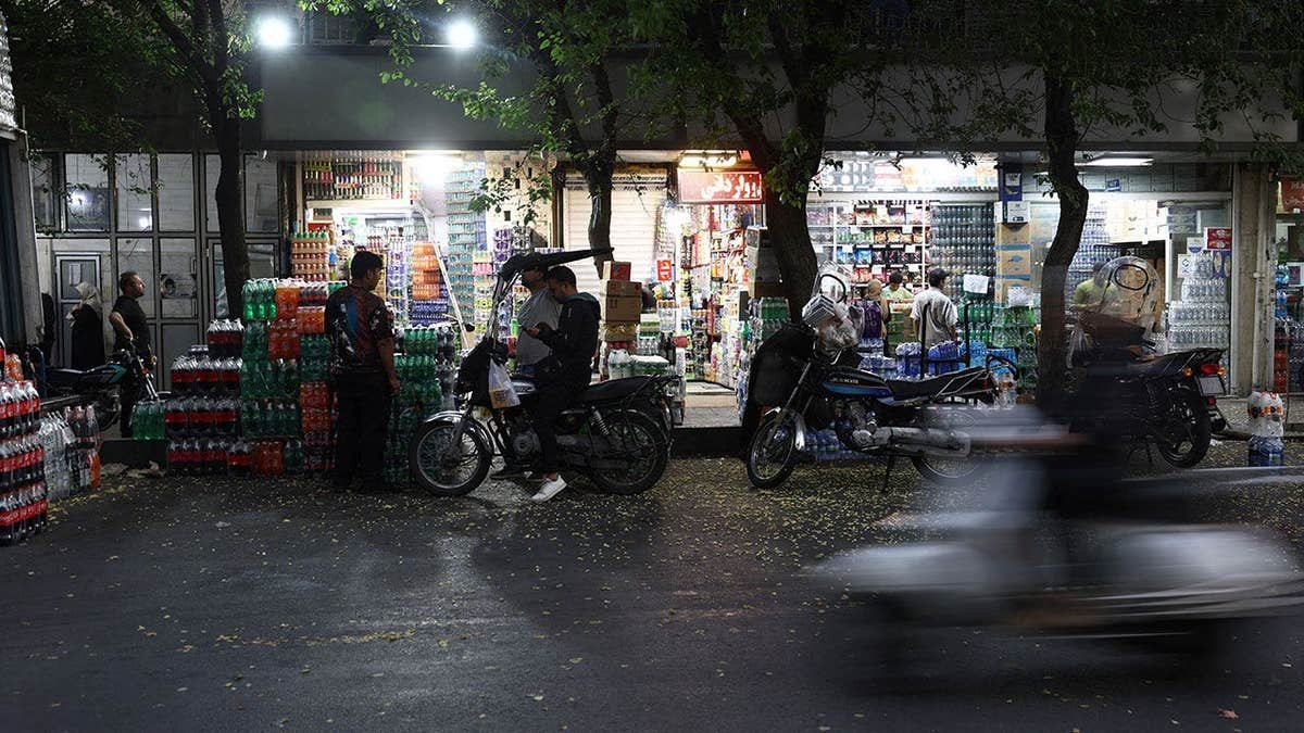 People shop in a local market in Tehran, Iran