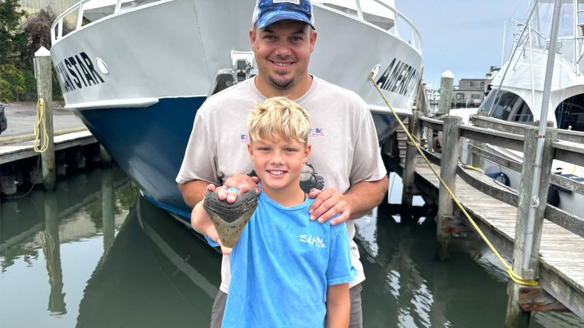 Mike and Bo holding tooth on New Jersey beach