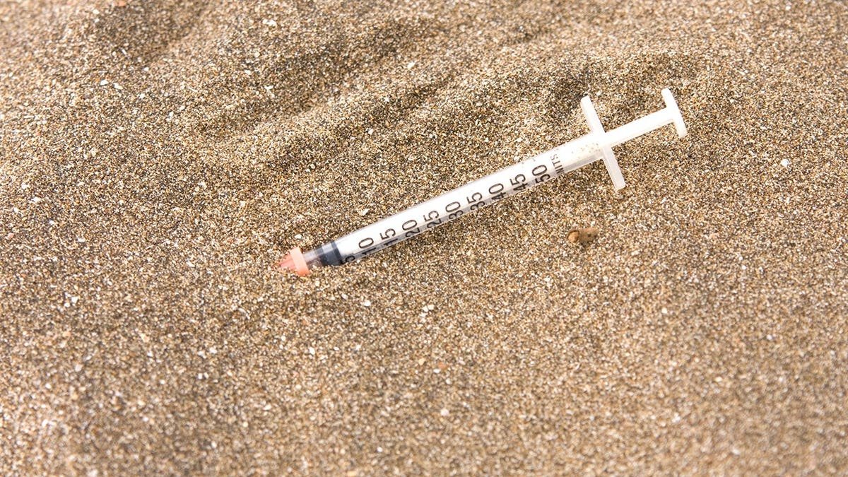 Stock image of syringe on beach