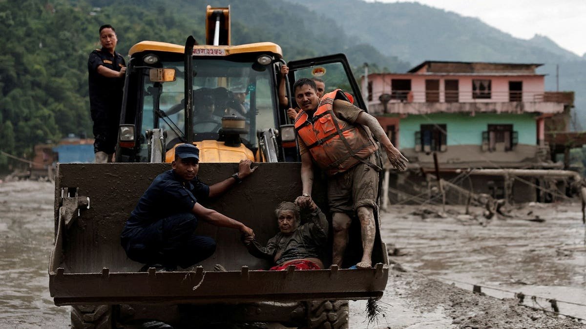 A survivor is transported to a safer place in a JCB following a flash flood at Trishuli in Nuwakot district, Nepal, August 26, 2026.