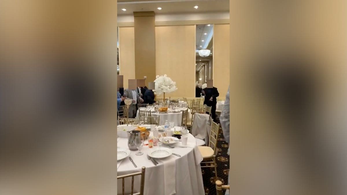 Cellphone video shows wedding guests gathered inside an Ohio banquet hall as a fight breaks out.