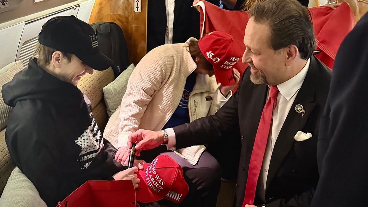 Sebastian Gorka hands Robert Gilman a cigar