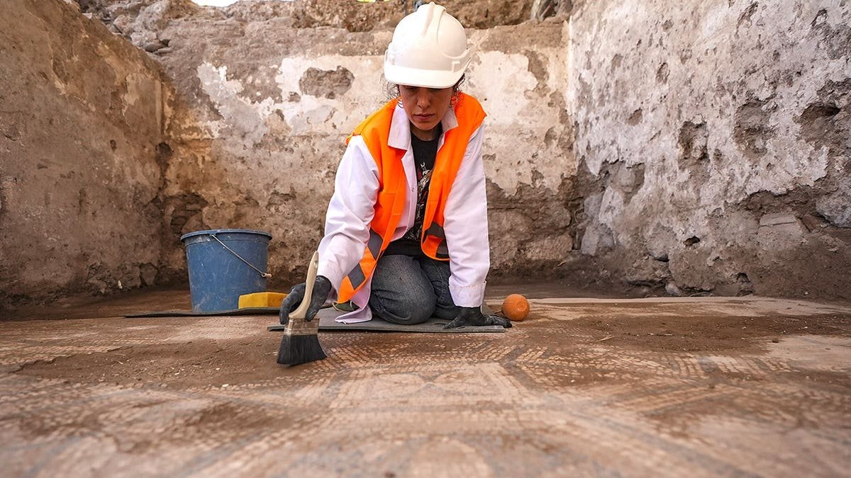 Female archaeologist working near Turkish mosaic